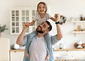 a man in white shirt carrying a child on his shoulders