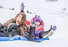 a group of people sledding in the snow