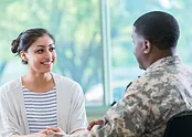 a soldier and a woman in stripes talking