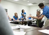 people in a room conducting a meeting