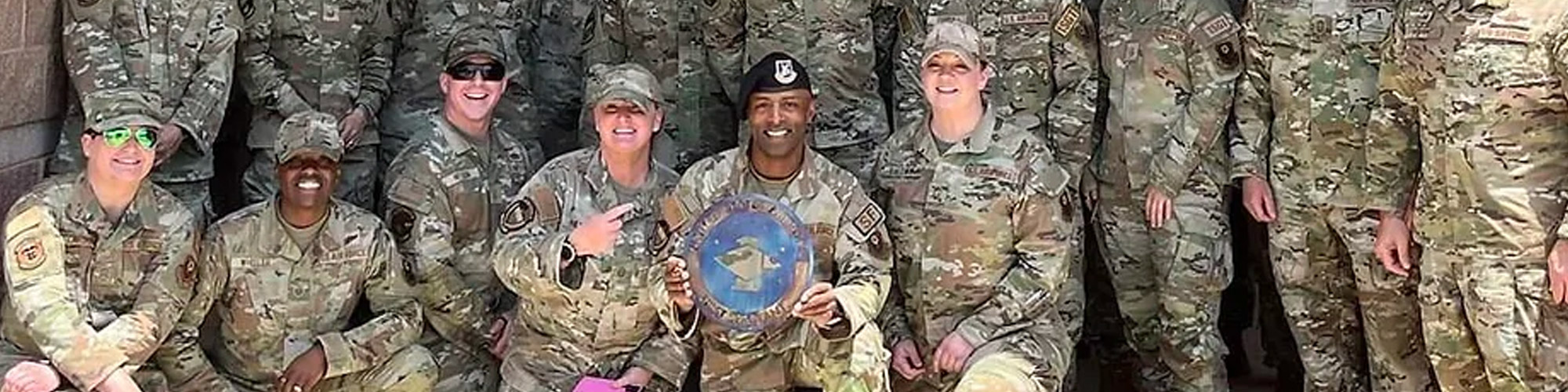 A group of soldiers standing together, smiling and posing for a picture