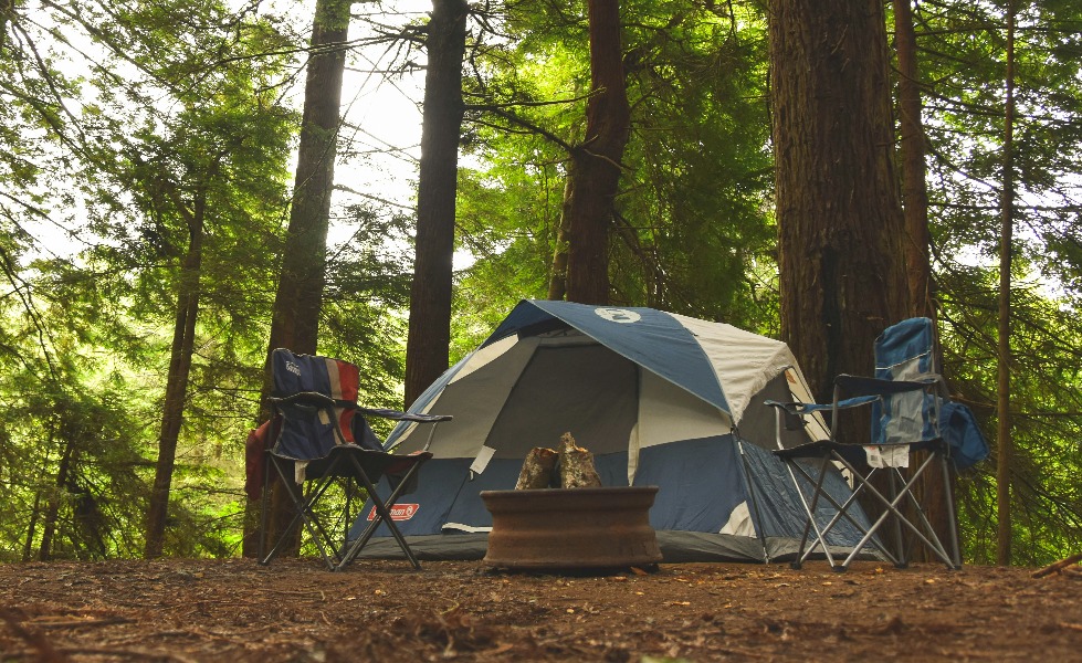 a tent and chairs in the woods