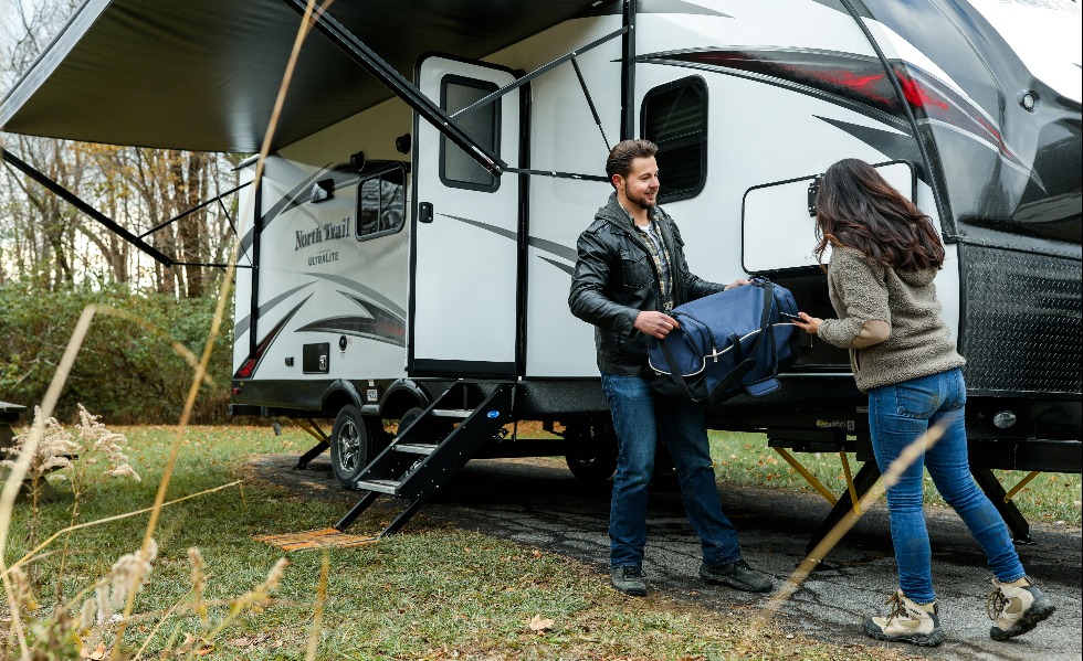 a man and a woman standing next to an RV