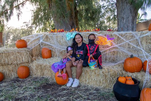 two children in clothing sitting on hay bales<br />
