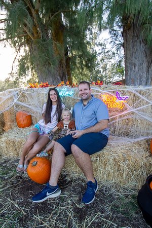 a family in clothing sitting on hay bales<br />
