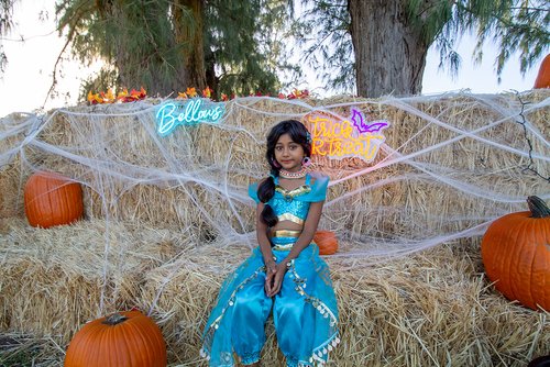 a child in a garment sitting on hay<br />
