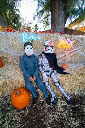 two children in clothing sitting on a hay bale<br />
