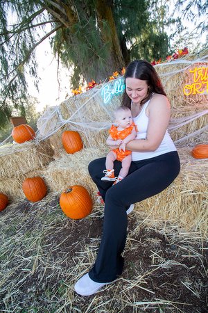 a person sitting on hay with a baby