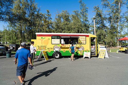 a food truck with people walking by