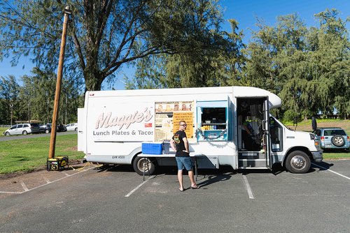 a food truck with people walking by