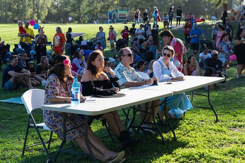 a group of people sitting at tables in a park