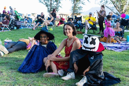 a group of people in clothing sitting on grass<br />
