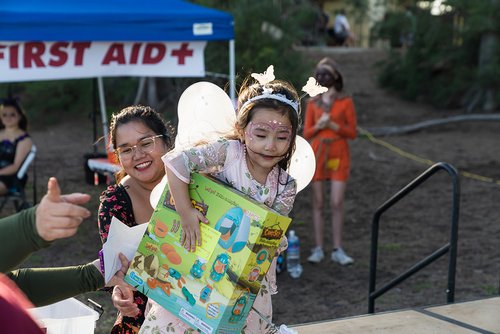 a child holding a box with wings and a person in garment<br />
