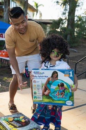 a child holding a box and a person in garment