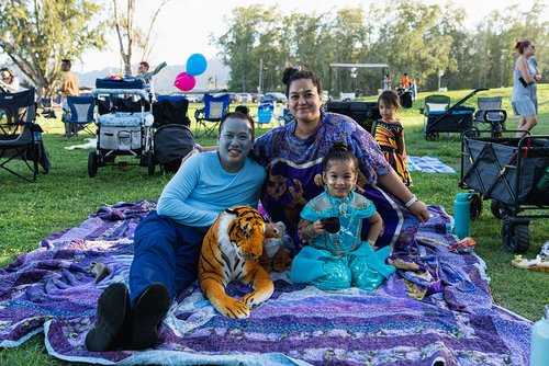 a group of people in garments sitting at a park