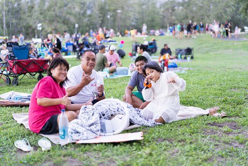 a group of people sitting at the grass