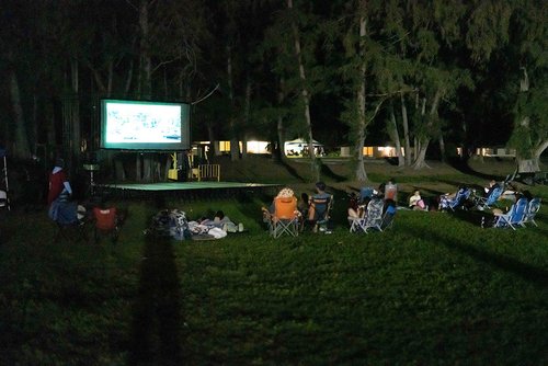 a group of people sitting in chairs in a grassy area<br />
