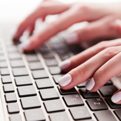 close-up of hands typing on a keyboard