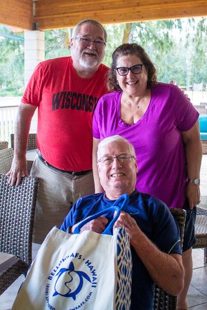 a group of people posing for a photo holding a bag