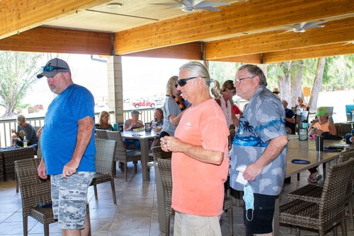 a group of people standing under a covered patio