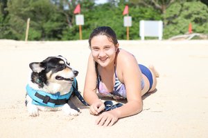 a person lying on the sand with a dog<br />
