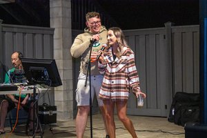 a man and a woman singing at on a microphone