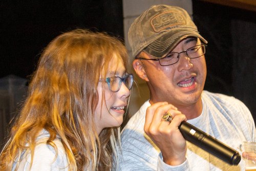 man and woman singing on a microphone