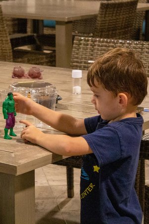 a boy playing the hulk plastic toy