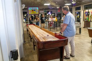 a man playing shuffle board