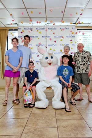 a group of people sitting on a bench with a person in a bunny garment<br />
