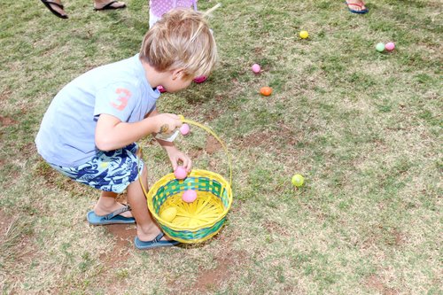 a child picking up eggs from a basket<br />
