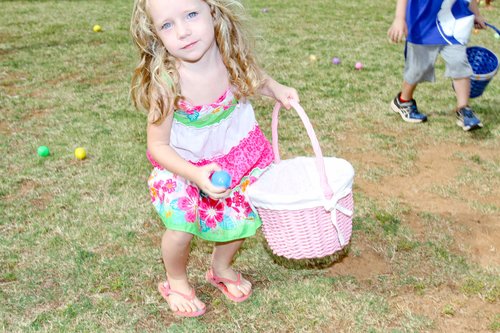 a child picking up eggs from a basket<br />
