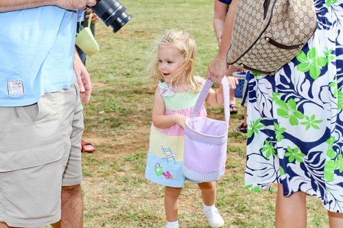 a child holding a bag and a camera<br />
