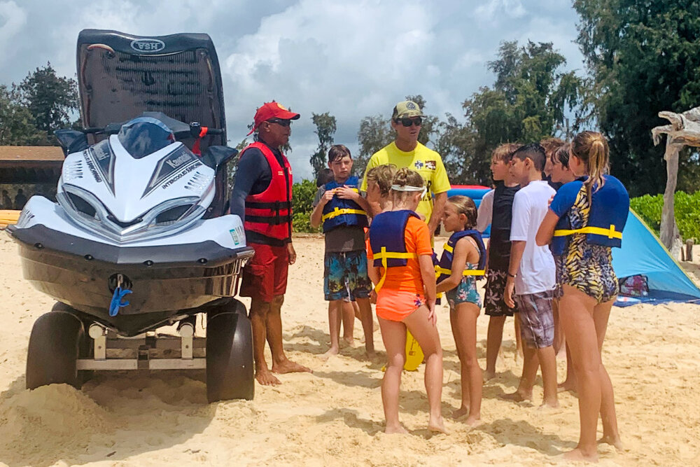 a group of people standing around a jet ski