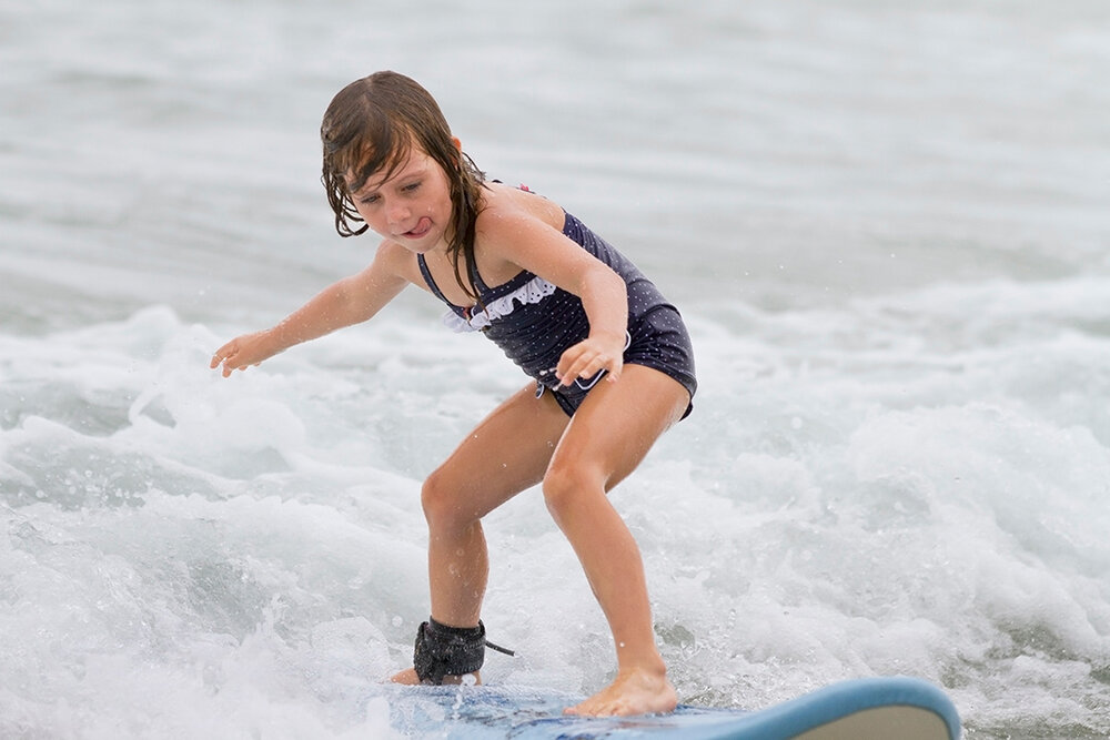 a child on a surfboard in the ocean