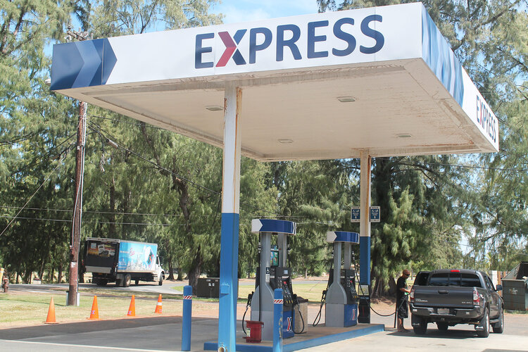 a gas station with a truck and a truck in the background