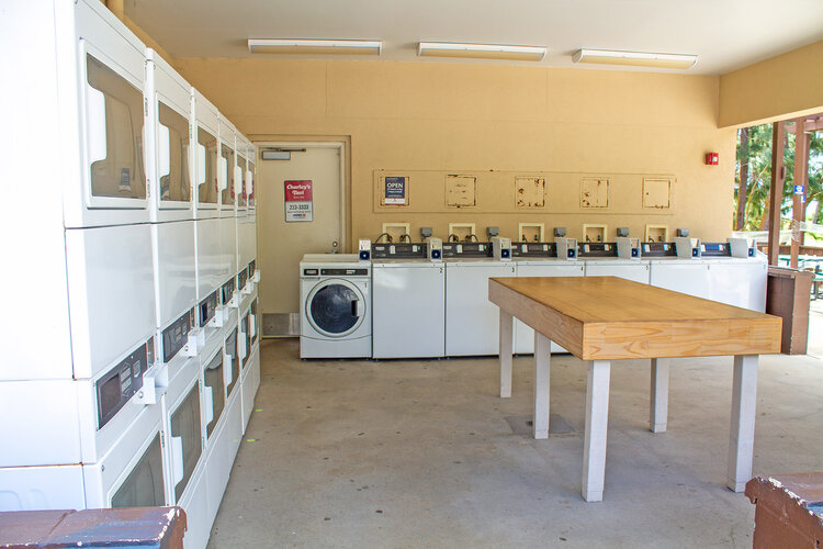 a laundry room with a table and washing machines