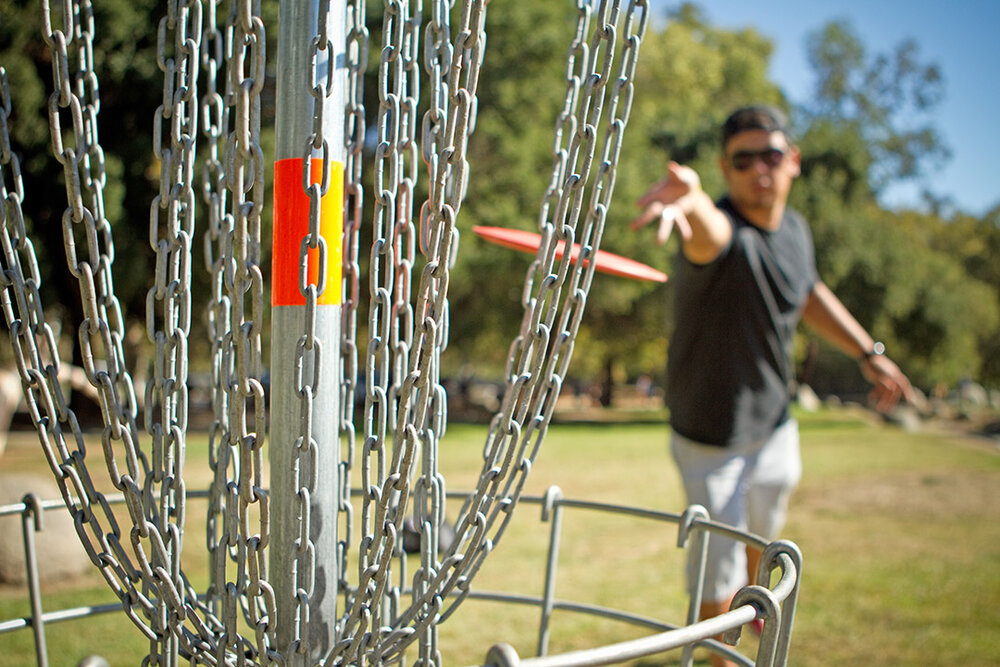 a person throwing a frisbee in a metal net