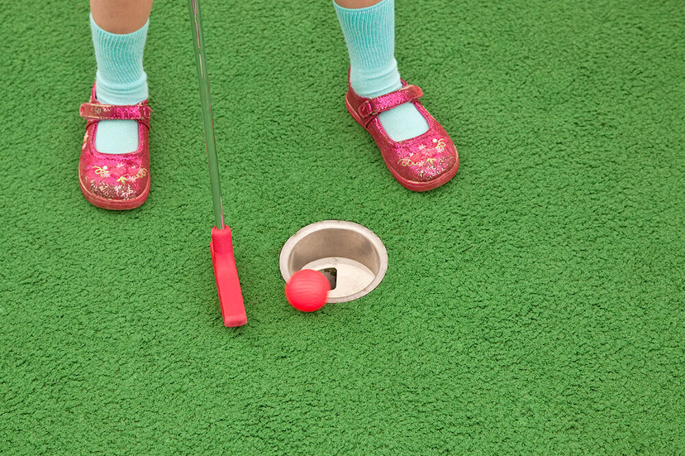 a child playing mini golf