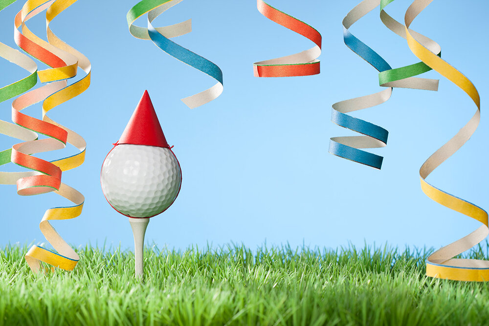 a golf ball on a tee with a party hat on it