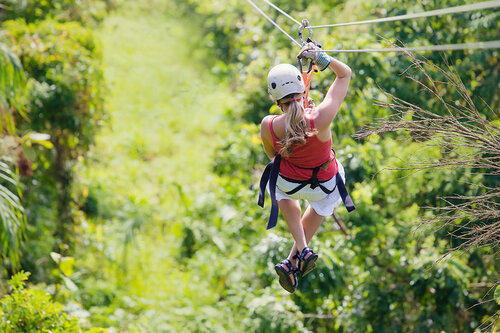 a person in a helmet on a zip line