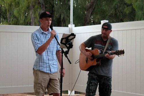 a person holding a microphone and a person playing guitar<br />
