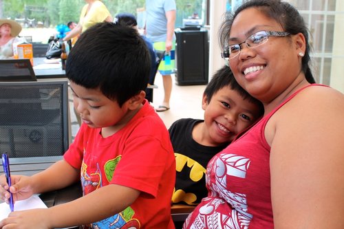 a person and two children sitting at a table<br />
