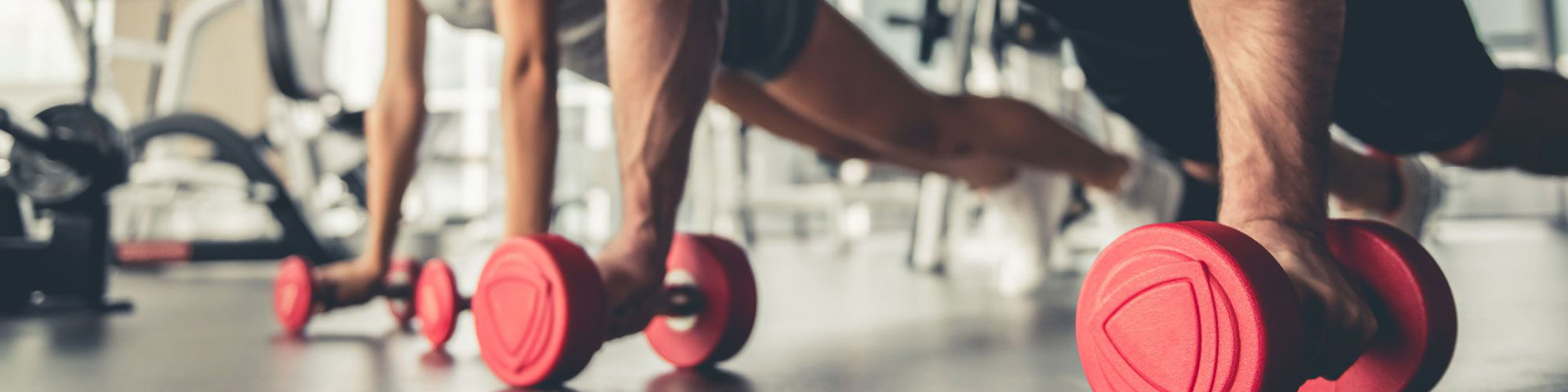 two people doing push ups with weights